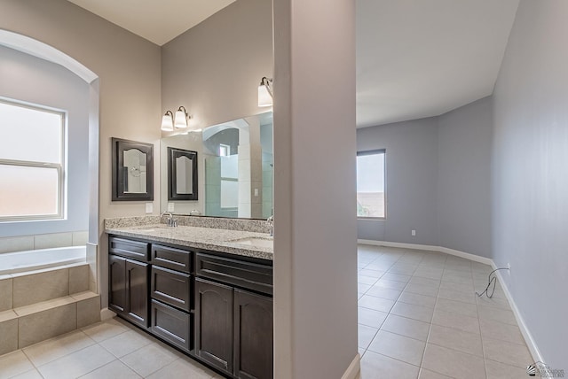 full bathroom featuring tile patterned floors, a garden tub, and a sink