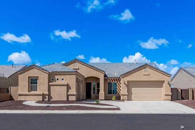 view of front facade featuring fence, stucco siding, concrete driveway, a garage, and a tile roof