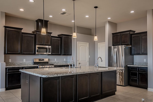 kitchen featuring visible vents, appliances with stainless steel finishes, an island with sink, and a sink