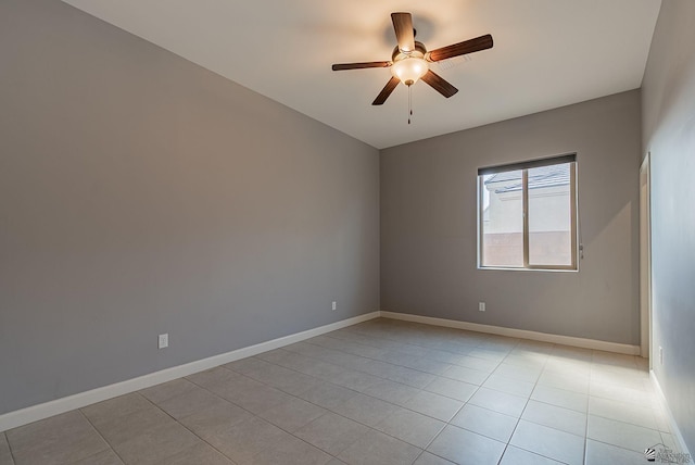 spare room featuring light tile patterned floors, baseboards, and a ceiling fan