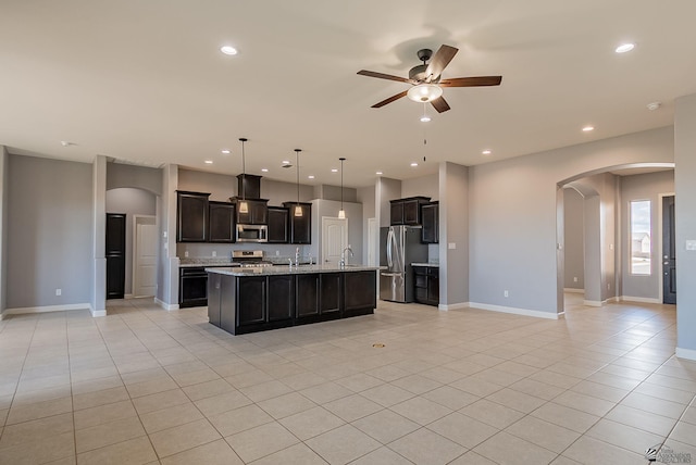 kitchen with a ceiling fan, open floor plan, recessed lighting, arched walkways, and appliances with stainless steel finishes