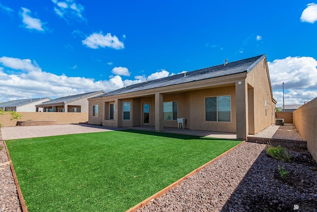 back of property featuring stucco siding, a lawn, a patio, a fenced backyard, and cooling unit