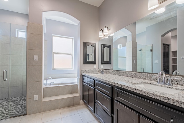 bathroom with tile patterned flooring, double vanity, a stall shower, a bath, and a sink