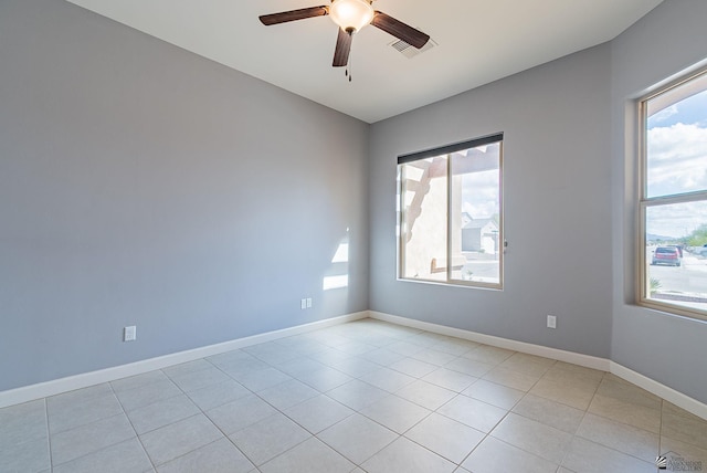 unfurnished room with light tile patterned floors, visible vents, baseboards, and ceiling fan