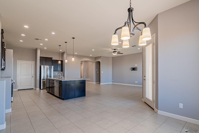 kitchen featuring visible vents, ceiling fan with notable chandelier, a sink, arched walkways, and appliances with stainless steel finishes