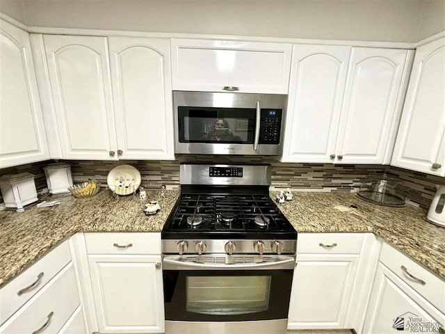 kitchen with white cabinets, stone counters, backsplash, and appliances with stainless steel finishes