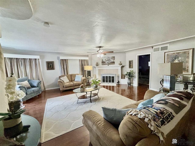 living room featuring a textured ceiling, dark hardwood / wood-style flooring, and ceiling fan