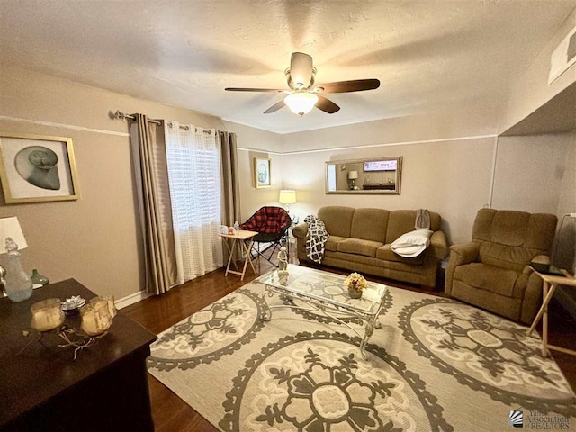 living room featuring ceiling fan and dark hardwood / wood-style flooring