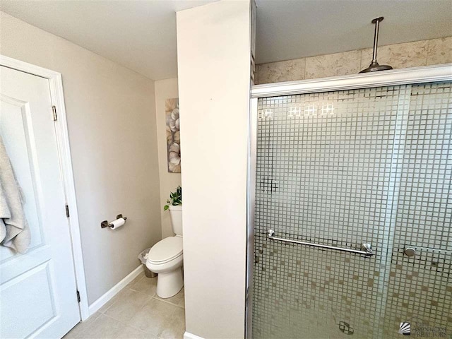 bathroom with tile patterned floors, toilet, and walk in shower