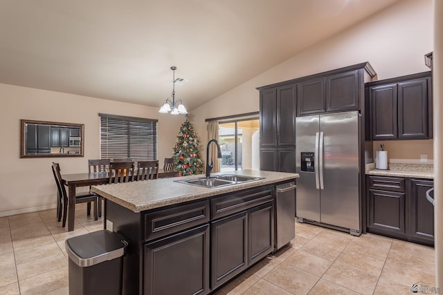 kitchen with sink, stainless steel fridge with ice dispenser, a notable chandelier, an island with sink, and vaulted ceiling