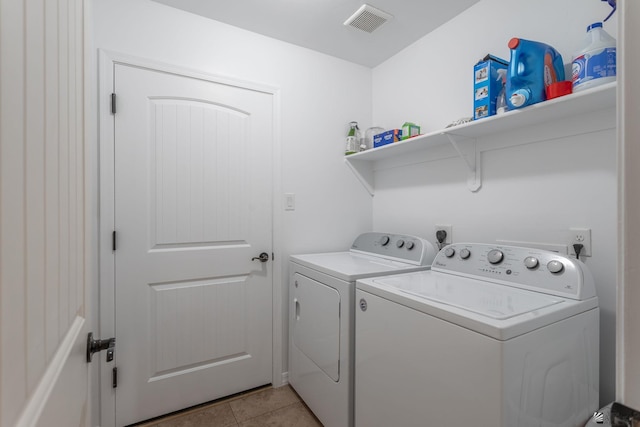 laundry area featuring washer and dryer and light tile patterned flooring