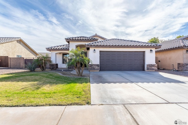 mediterranean / spanish-style house featuring a front yard and a garage