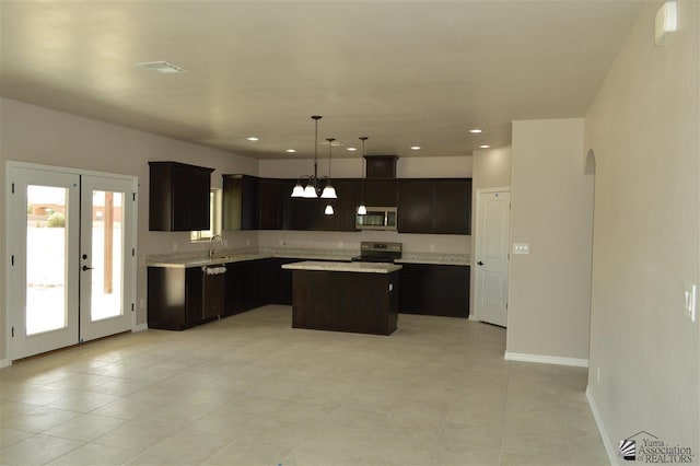 kitchen featuring a center island, french doors, hanging light fixtures, appliances with stainless steel finishes, and dark brown cabinetry