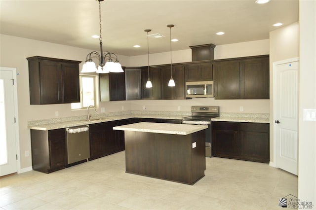 kitchen with a center island, sink, hanging light fixtures, appliances with stainless steel finishes, and dark brown cabinetry