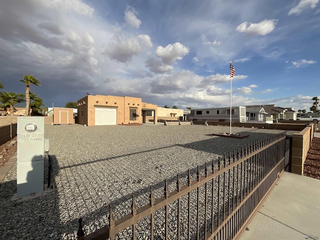 view of property's community with gravel driveway and fence