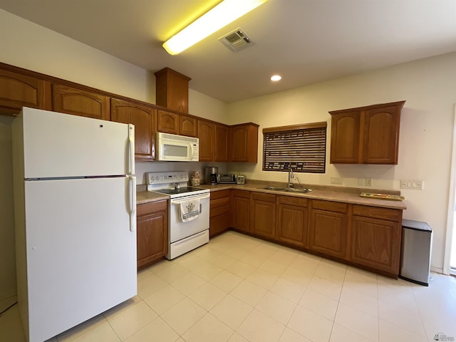 kitchen featuring light countertops, recessed lighting, white appliances, a sink, and visible vents