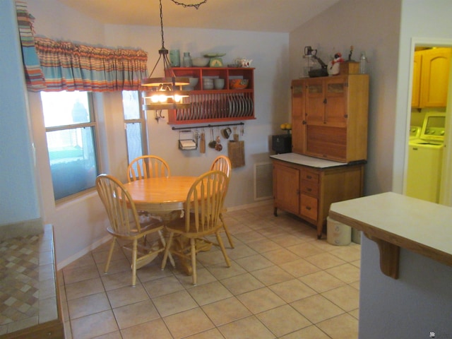 dining area featuring washer and clothes dryer and light tile patterned floors