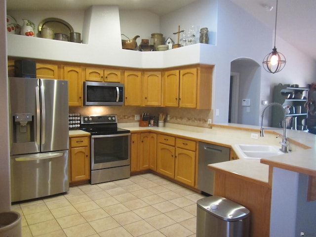 kitchen with sink, decorative light fixtures, light tile patterned floors, kitchen peninsula, and stainless steel appliances