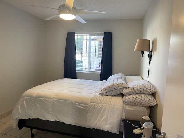 bedroom featuring tile patterned floors, ceiling fan, and a textured ceiling