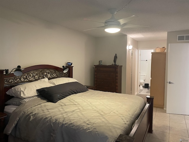 bedroom featuring ceiling fan, light tile patterned floors, and a textured ceiling