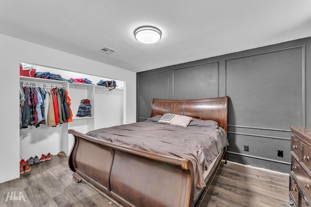 bedroom with wood-type flooring and a textured ceiling