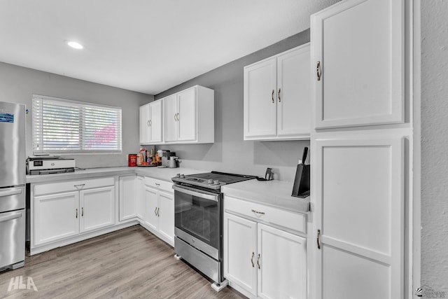 kitchen with appliances with stainless steel finishes, light hardwood / wood-style flooring, and white cabinets