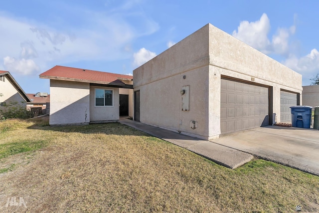 exterior space featuring a garage and a lawn