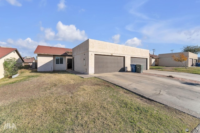 pueblo revival-style home featuring a garage and a front lawn