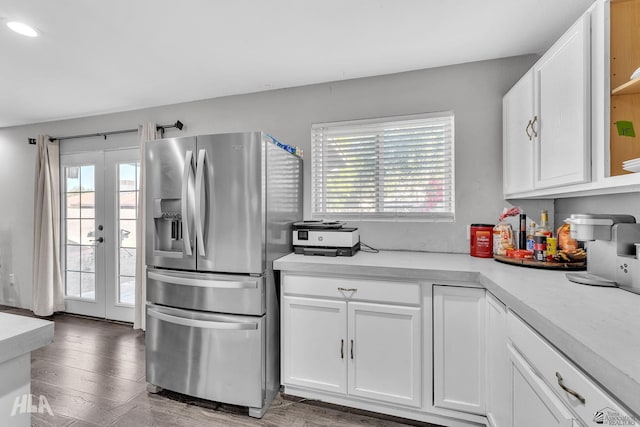 kitchen featuring french doors, a healthy amount of sunlight, stainless steel fridge, and white cabinets