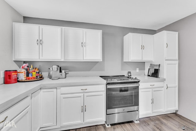 kitchen with stainless steel range with electric cooktop, light hardwood / wood-style floors, and white cabinets