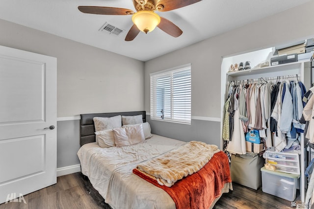 bedroom with dark wood-type flooring, ceiling fan, and a closet