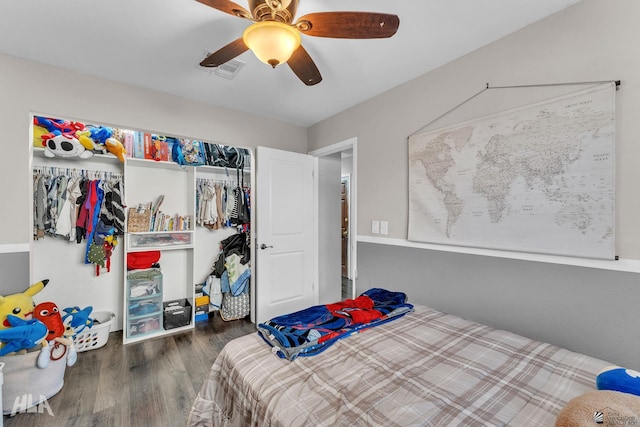 bedroom with ceiling fan, dark hardwood / wood-style flooring, and a closet