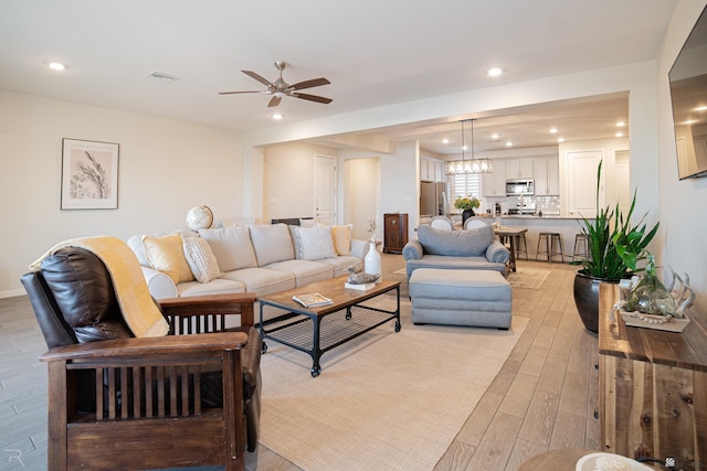 living room featuring ceiling fan and light wood-type flooring