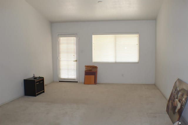 unfurnished room featuring light carpet