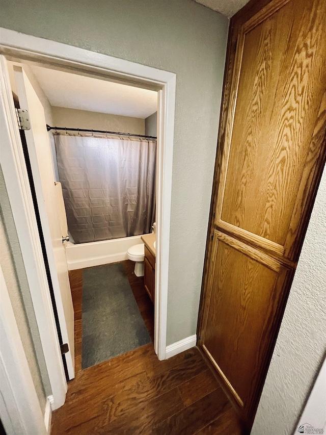 full bathroom featuring hardwood / wood-style floors, vanity, toilet, and shower / bath combo