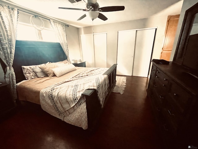 bedroom with ceiling fan and multiple closets