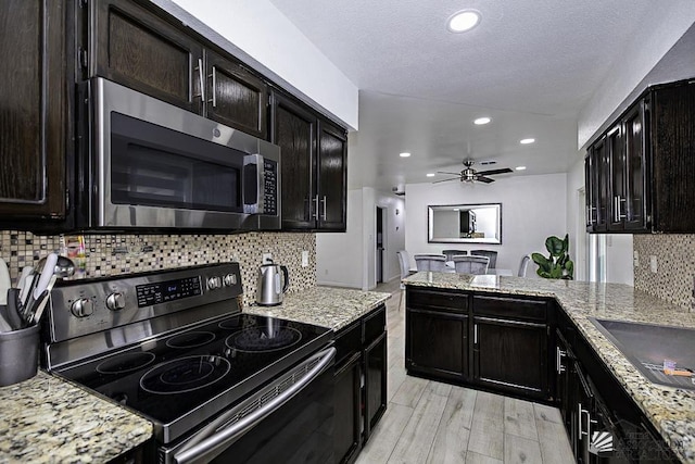 kitchen with ceiling fan, electric range, light wood-style floors, light stone countertops, and stainless steel microwave