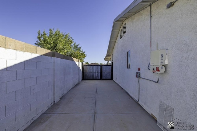 view of side of property featuring fence, a gate, and stucco siding