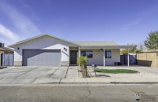 single story home featuring driveway, an attached garage, fence, and stucco siding