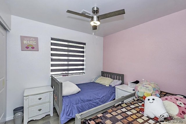 bedroom with visible vents, wood finished floors, and a ceiling fan