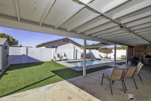 view of patio with a shed, an outdoor structure, a fenced backyard, and a fenced in pool