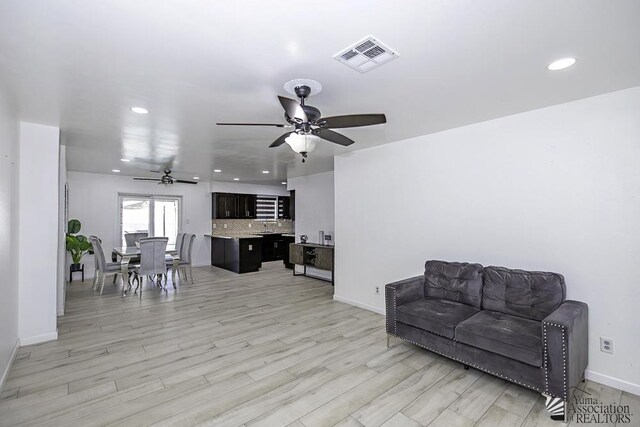 living area with ceiling fan and light hardwood / wood-style floors