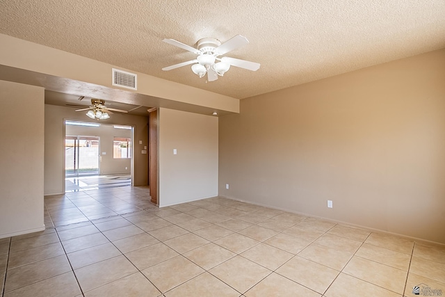 tiled empty room featuring a textured ceiling and ceiling fan