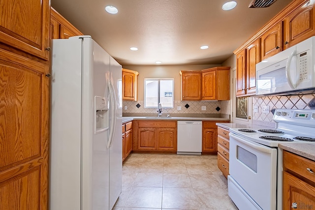 kitchen with white appliances, light tile patterned floors, sink, and backsplash