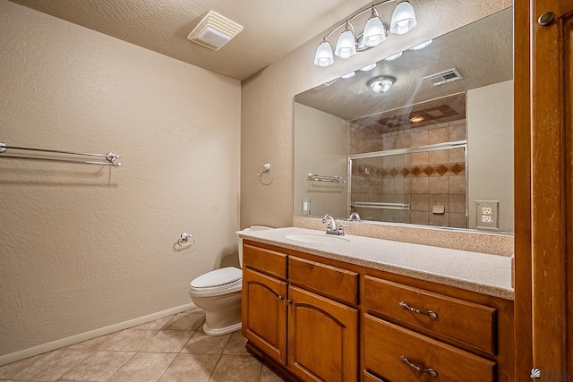 bathroom featuring toilet, an enclosed shower, a textured ceiling, vanity, and tile patterned flooring