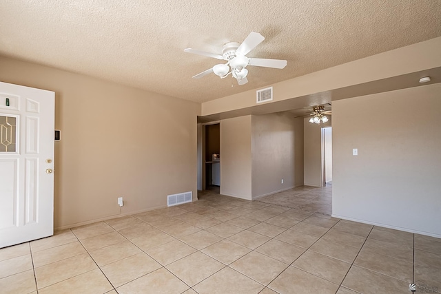 tiled empty room with a textured ceiling and ceiling fan