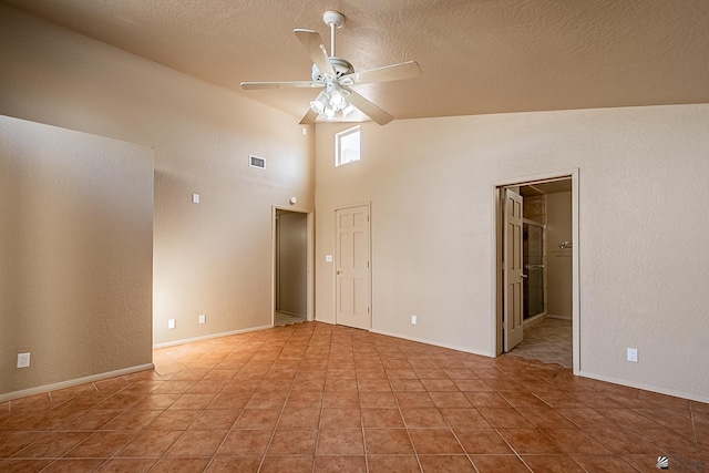 tiled spare room with ceiling fan and a textured ceiling