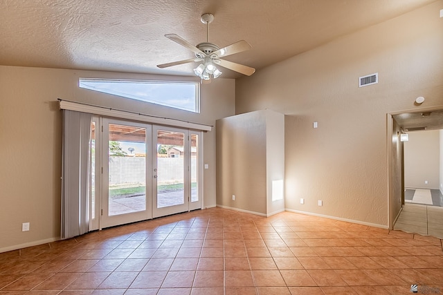 tiled spare room featuring a textured ceiling, high vaulted ceiling, french doors, and ceiling fan