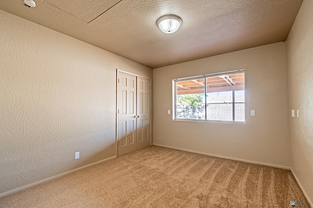 carpeted spare room with a textured ceiling