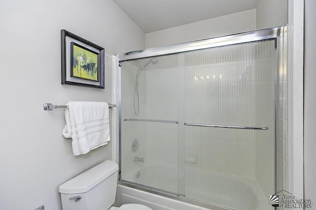 bathroom featuring combined bath / shower with glass door and toilet